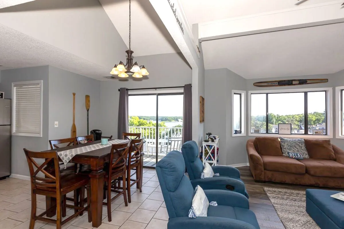 A welcoming dining and seating area adjacent to large windows offering scenic vistas. The comfortable setting invites family gatherings, casual dining, or relaxing with a book while soaking in the view. The natural light enhances the warm and relaxed mood of the space.